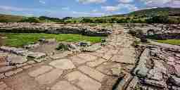 Old cobblestone roman road curving through the english countryside.